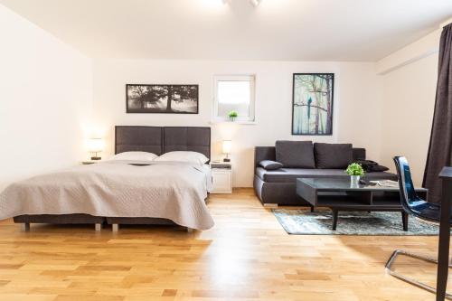 a bedroom with a bed and a couch at The Greenery Apartments in Vienna