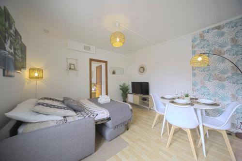 a living room with a bed and a table and chairs at L'Eldorado - By BEST KEYS - Idéal Pros, Couple & Famille - 1 Chambre et 1 Canapé-Lit Convertible - Cosy & Confort - Centre Ville - Netflix & WiFi Fibre - Machine à Café Nespresso - Check-in Autonome - Parking Facile & Gratuit in Sens
