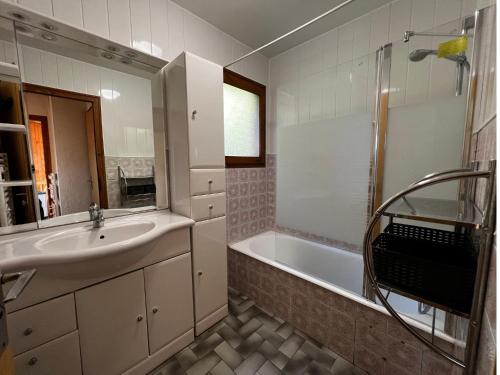 une salle de bain avec un lavabo et une baignoire dans l'établissement Abricot - Appart dans chalet, à La Clusaz