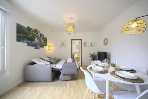 a living room with a table and a couch at L'Eldorado - By BEST KEYS - Idéal Pros, Couple & Famille - 1 Chambre et 1 Canapé-Lit Convertible - Cosy & Confort - Centre Ville - Netflix & WiFi Fibre - Machine à Café Nespresso - Check-in Autonome - Parking Facile & Gratuit in Sens
