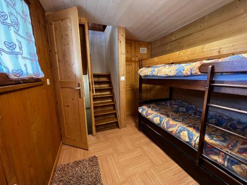 Zimmer mit 2 Etagenbetten und einer Treppe in der Unterkunft Abricot - Appart dans chalet in La Clusaz