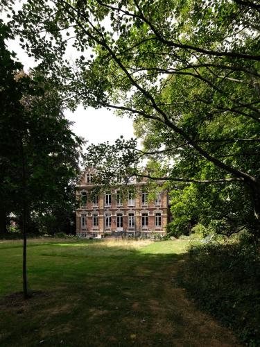 a large brick building in the middle of a field at Mille et une feuilles in Saint-Martin-lez-Tatinghem