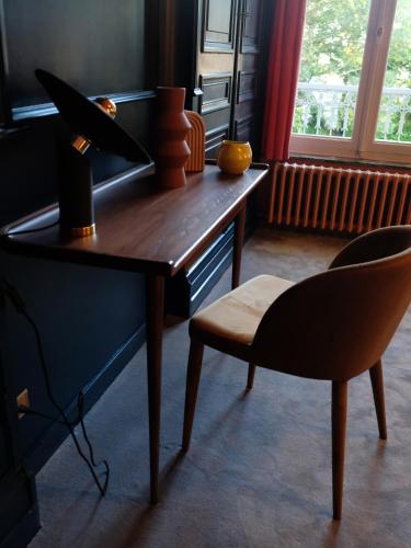 a desk and a chair in a room with a window at Mille et une feuilles in Saint-Martin-lez-Tatinghem