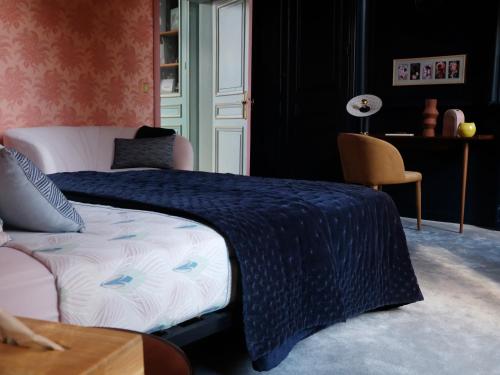 ein Schlafzimmer mit einem Bett mit einer blauen Decke in der Unterkunft Mille et une feuilles in Saint-Martin-lez-Tatinghem