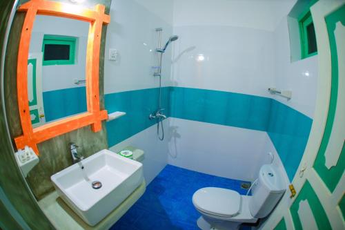 y baño con aseo blanco y lavamanos. en International Beach Hotel & Restaurant, en Hikkaduwa