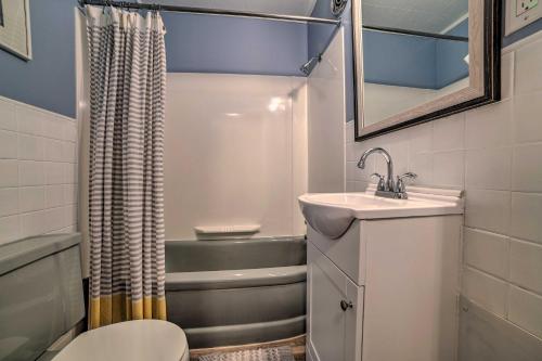 a small bathroom with a sink and a tub at Comfy Burt Lake Abode - On-Site Lake Access! 