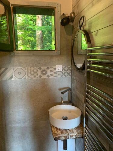 baño con lavabo y ventana en Off mode - Erdei faház a tóparton, en Komló