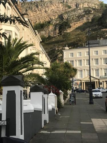 a street with buildings and a mountain in the background at ORME RISE - Beautiful first floor apartment in Llandudno