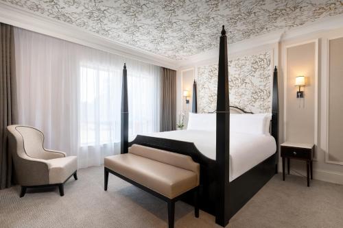 a hotel room with a bed and a chair at Fairmont Windsor Park in Windsor