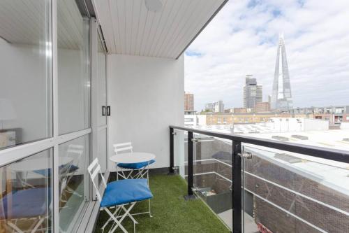 a balcony with two chairs and a view of the city at Spacious 2 Bedroom Flat on Bermondsey St in London