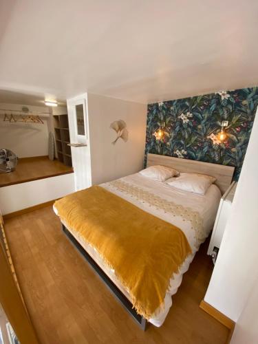 une chambre avec un grand lit avec un tableau au mur dans l'établissement Le panorama de la vicomté, à Dieppe