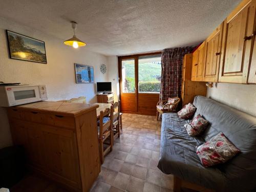 Elle comprend un petit salon avec un canapé et un bureau. dans l'établissement Biblos 15 - 2 pieces proche pistes, à La Clusaz