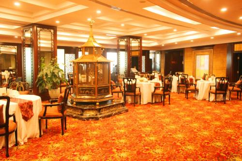 a dining room with tables and chairs and a large room with ayrinth at The Presidential Beijing in Beijing