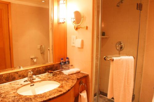 a bathroom with a sink and a shower at The Presidential Beijing in Beijing