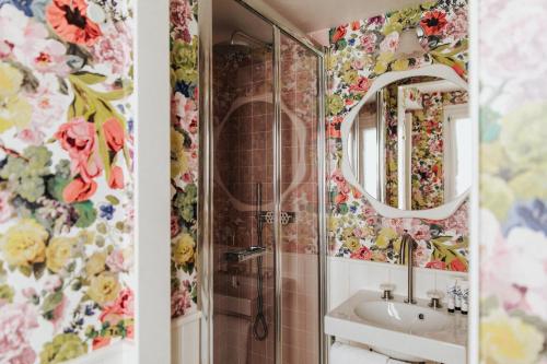 a bathroom with floral wallpaper and a sink at Hôtel Bienvenue in Paris