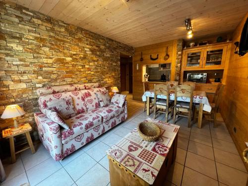 un salon avec un canapé et un mur de briques dans l'établissement Elan 7 - Appartement 2 chambres, à La Clusaz