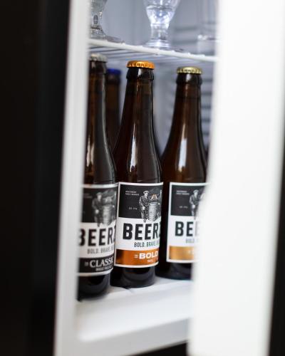 a row of beer bottles in a refrigerator at Beerze Brouwerij Hotel in Vessem