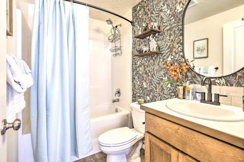 a bathroom with a toilet and a sink and a mirror at Prismatic Boise Retreat with Fenced Backyard! in Boise