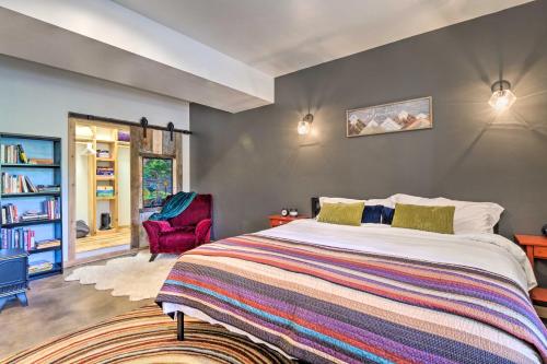 a bedroom with a large bed and a red chair at 24-0132 Alma Retreat with Deck 17 Mi to Skiing in Fairplay