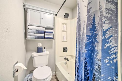 baño con aseo y cortina de ducha azul en Ideally Located Buckley Apartment with Balcony!, en Buckley