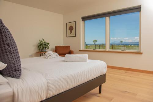 Litua Luxury self-catering with stunning sea views في آريسايغ: غرفة نوم بسرير ونافذة كبيرة