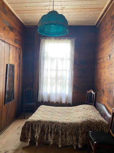 a bedroom with a bed and a blue wall at გურული ეზო*Gurian yard in Chala