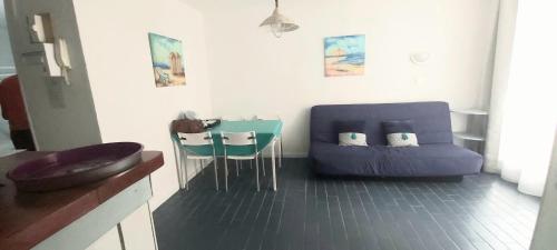un salon avec un canapé bleu et une table dans l'établissement Super T2 joli balcon centre port du Cap d'Agde, au Cap d'Agde
