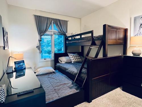 a bedroom with two bunk beds and a desk at Diamond Adventure Slope Side with Foosball and Arcade at Wintergreen Resort in Wintergreen