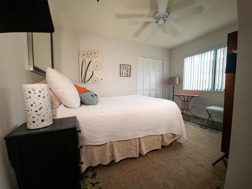 - une chambre avec un lit blanc et un ventilateur de plafond dans l'établissement Desert Dream, à Palm Desert
