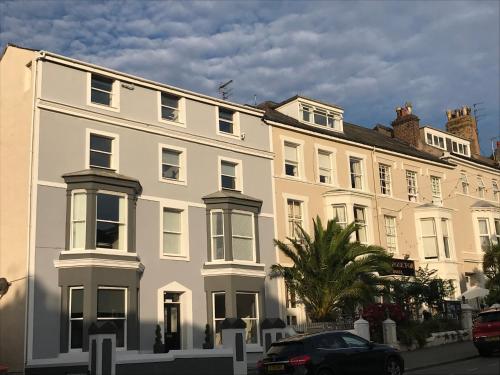 a white building with a car parked in front of it at ORME RISE - Beautiful first floor apartment in Llandudno