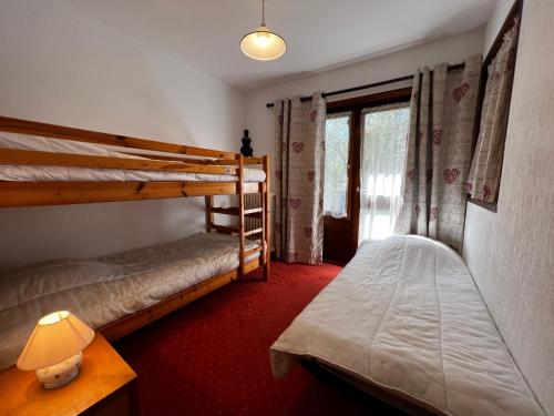 une chambre avec deux lits superposés et une fenêtre dans l'établissement Viking 23 - Appartement 5 pers centre du village, à La Clusaz