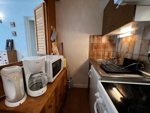 une cuisine avec un mixeur et un four micro-ondes sur un comptoir dans l'établissement Viking 23 - Appartement 5 pers centre du village, à La Clusaz