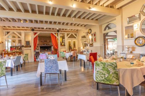 a restaurant with tables and chairs in a room at Château Corneille in Vieux-Villez