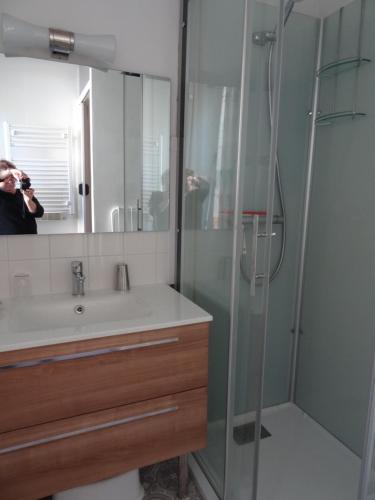 une personne prenant une photo d'une douche dans une salle de bains dans l'établissement Le Sancy, appart T2, 4 pers, centre ville du Mont Dore, à Le Mont-Dore