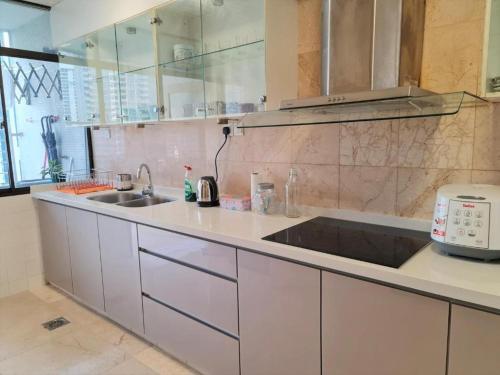 a kitchen with a sink and a counter top at Bukit Bintang Fahrenheit88 Apartment by Sarah's Lodge in Kuala Lumpur