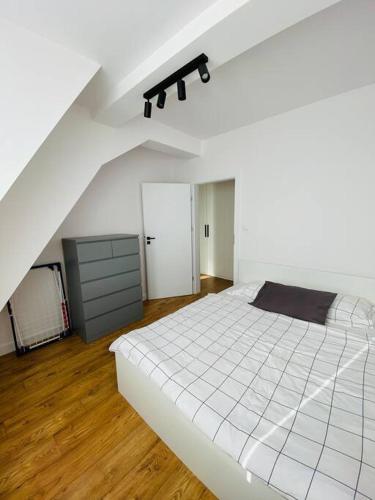 1 dormitorio con 1 cama blanca grande en el ático en Nowe 3 pokojowe mieszkanie z dużym tarasem, en Kalisz