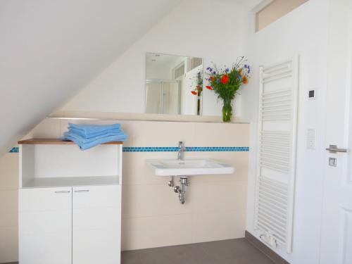 ein Bad mit einem Waschbecken und einem Spiegel in der Unterkunft "Jugendliebe" in Benz auf Usedom in Benz