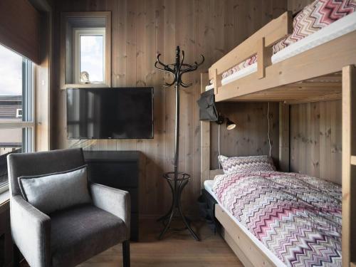 um quarto com um beliche e uma cadeira em Flott leilighet i Vestlia - ski in/ski out em Geilo