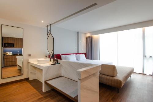 a bedroom with a bed and a sink and a chair at Centara Life Hotel Bangkok Phra Nakhon in Bangkok