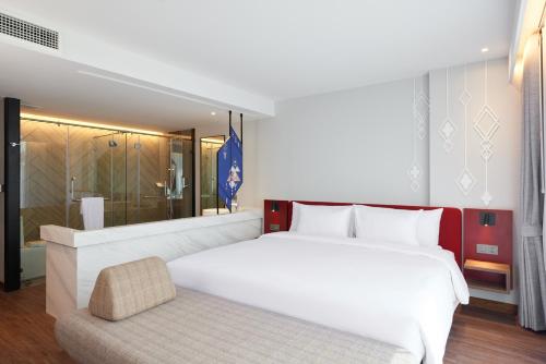 a bedroom with a large white bed and a shower at Centara Life Hotel Bangkok Phra Nakhon in Bangkok