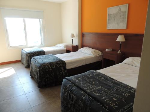 a hotel room with two beds and two ottomans at Park View Hotel & Residences in Campana
