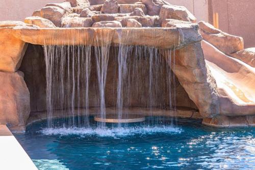 une cascade dans une piscine d'eau bleue dans l'établissement Beach Happy-Lake Close-Private Waterpark Oasis -sleeps 14, à Lake Havasu City