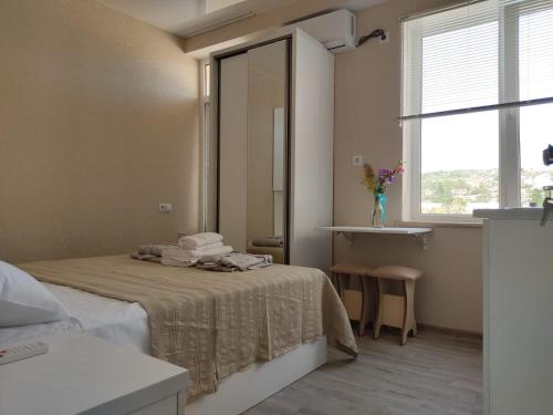 Schlafzimmer mit einem Bett mit einem Spiegel und einem Fenster in der Unterkunft Pushkin street Pearl in Kutaissi