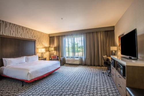a hotel room with a bed and a flat screen tv at Holiday Inn Portland West - Hillsboro by IHG in Hillsboro