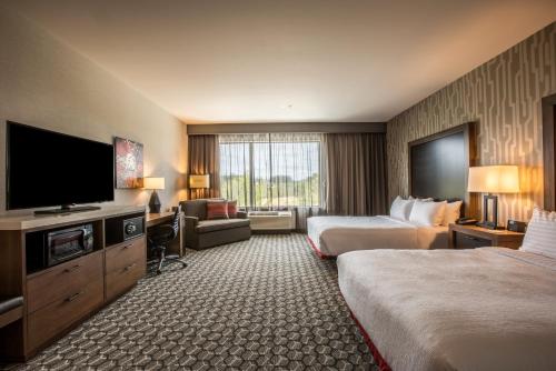 a hotel room with two beds and a flat screen tv at Holiday Inn Portland West - Hillsboro by IHG in Hillsboro