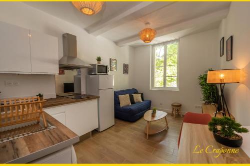 - une cuisine et un salon avec un canapé bleu dans la chambre dans l'établissement Le Craponne - Magnifique appartement cours principal plein centre avec parking, à Salon-de-Provence