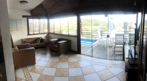 a living room with couches and a balcony at Casa em Geribá com piscina e vista para praia in Búzios