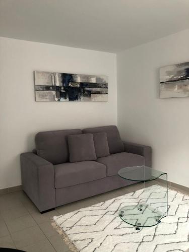 sala de estar con sofá y mesa de cristal en VEROMA PISOS, en Granada