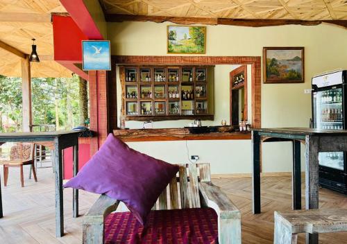 um bar com um sofá roxo num quarto em The Forest Resort - Lweza em Makindye