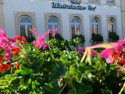 a building with a bunch of flowers in front of it at Hotel Waibstadter Hof in Waibstadt